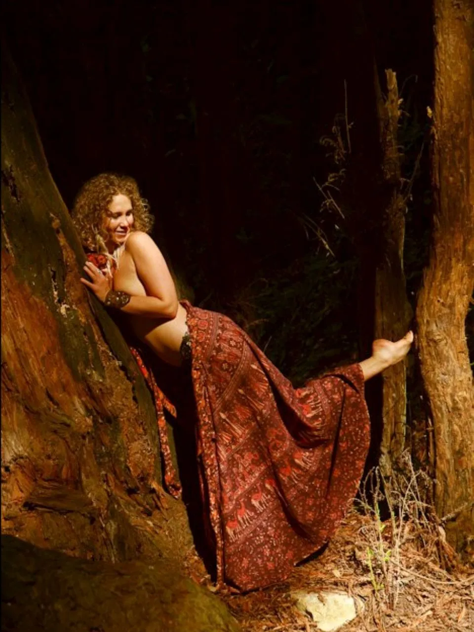 Chandra Zas in somatic practice against an ancient redwood at Esalen Institute on the Big Sur coast