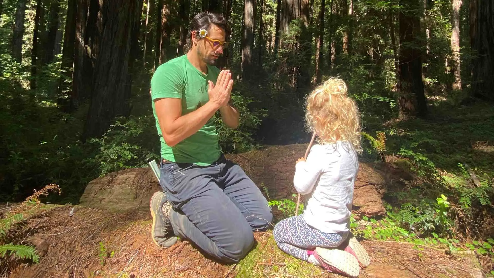 Father kneeling with daughter in a redwood grove, hands in prayer — Chandra Zas family practicing somatic parenting and presence